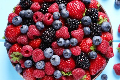 Photo of Different fresh ripe berries in bowl on table, top view