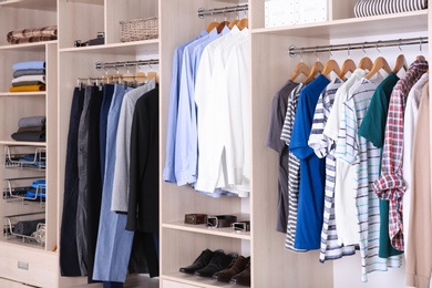 Photo of Large wardrobe with different clothes and shoes