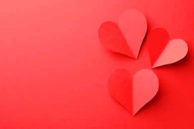 Paper hearts on red background, flat lay. Space for text