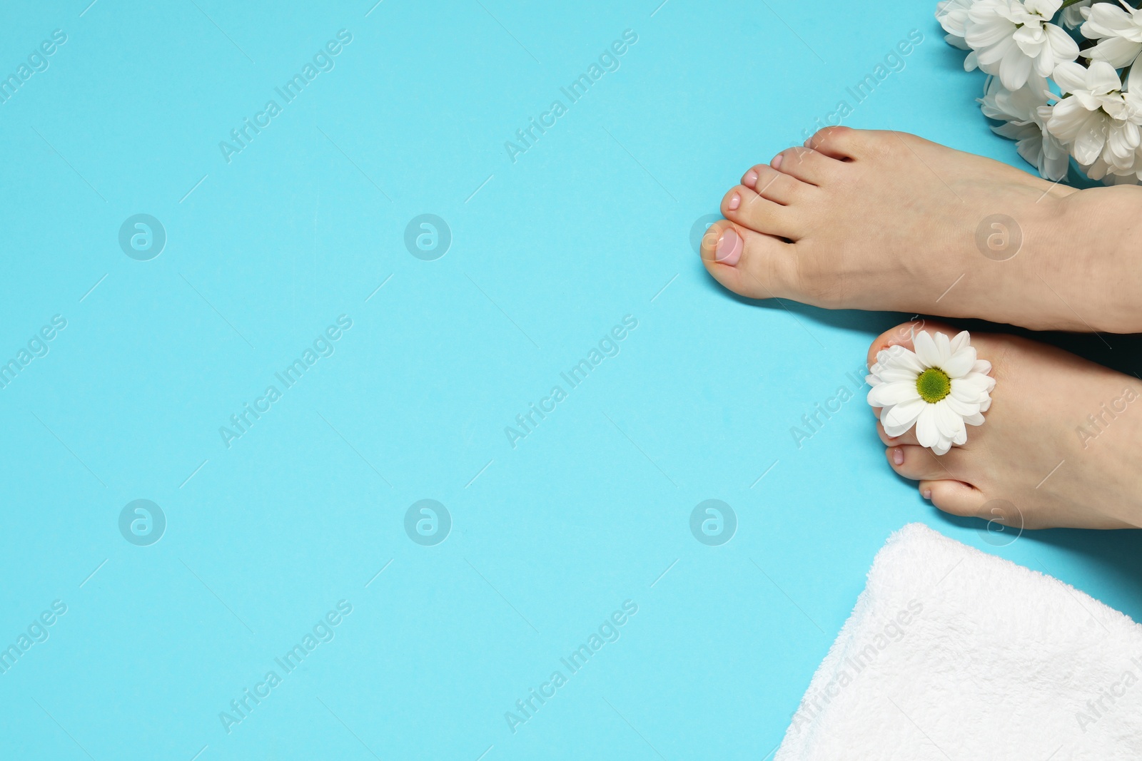 Photo of Closeup of woman with neat toenails after pedicure procedure on light blue background, top view. Space for text