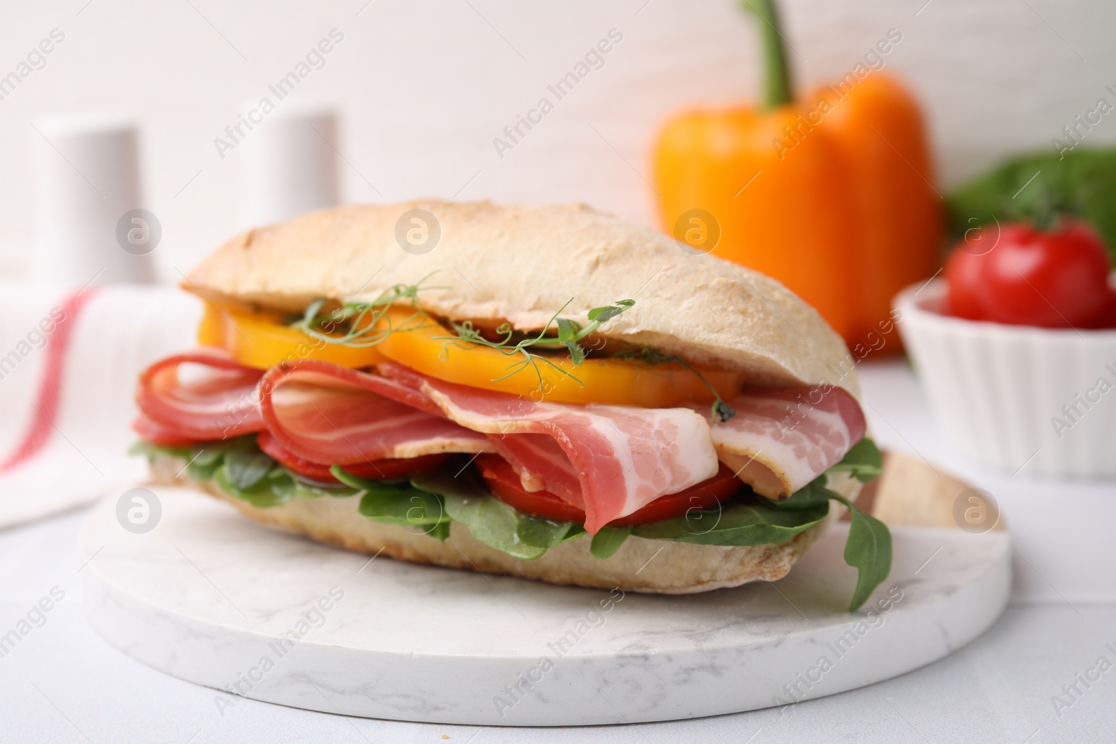 Photo of Tasty sandwich with bacon and bell pepper on white table, closeup