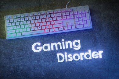 Image of Gaming disorder. Modern RGB keyboard on grey table, top view