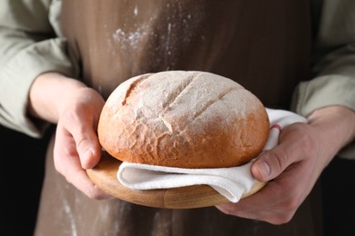 Woman holding one freshly baked bread, closeup