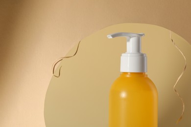 Photo of Hole with face cleansing product on beige background, closeup