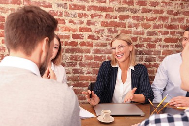 Photo of Businesswoman having meeting with her employees in office. Lady boss