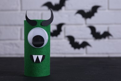 Spooky monster on black table, space for text. Handmade Halloween decoration