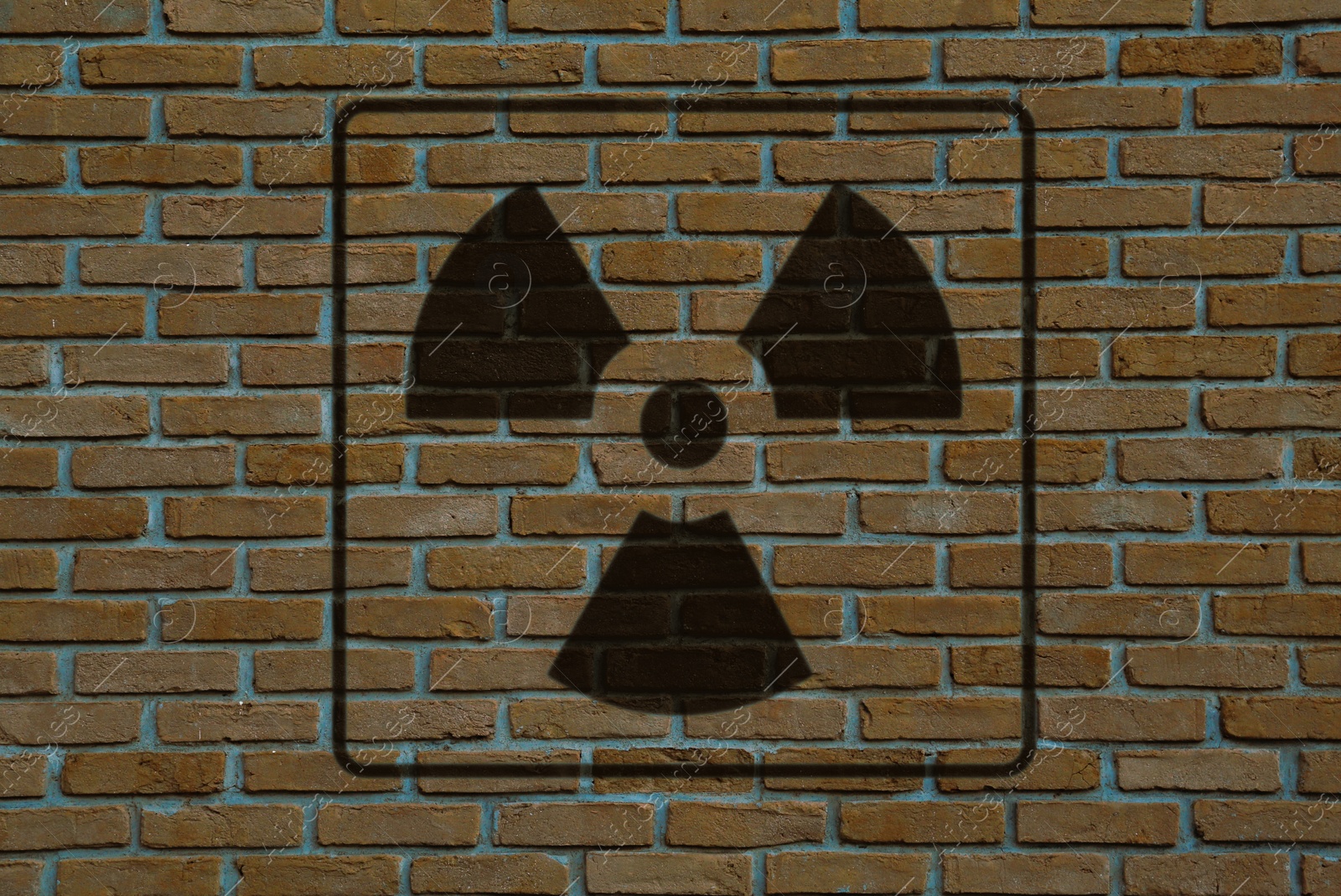 Image of Radioactive sign on brick wall. Hazard symbol