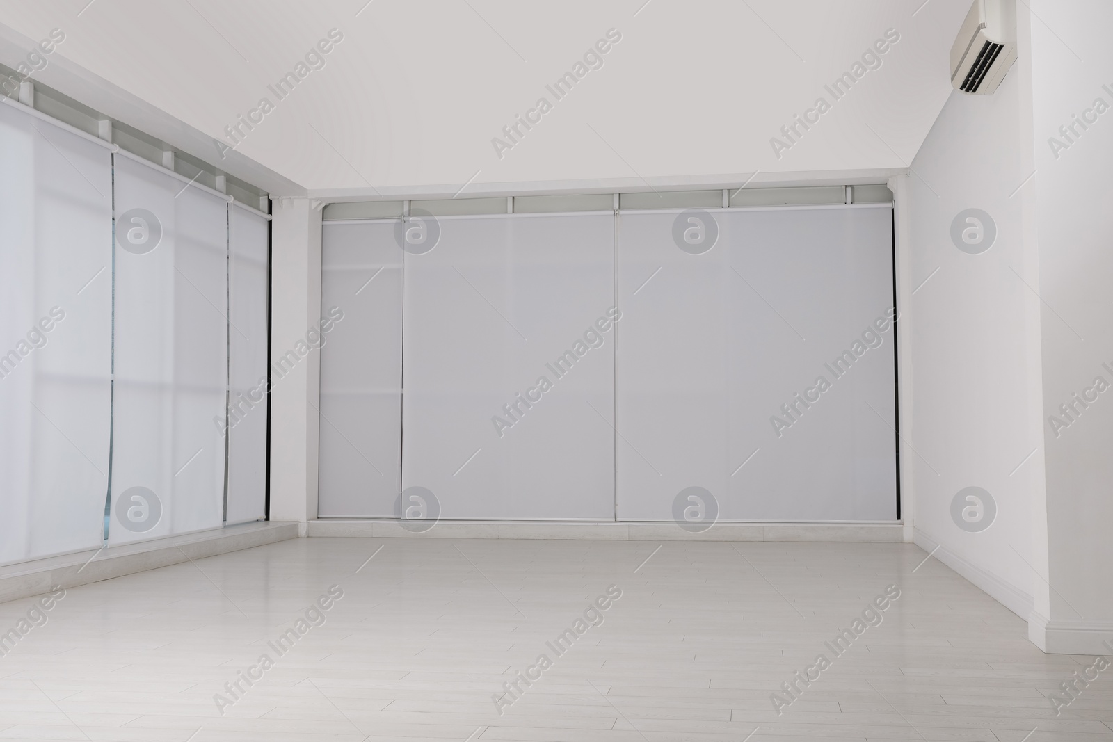 Photo of Empty room with white walls and laminated flooring