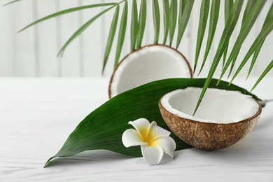 Photo of Composition with halves of coconut on white wooden background