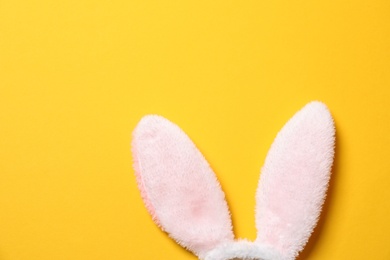 Photo of Funny Easter bunny ears on color background, top view with space for text