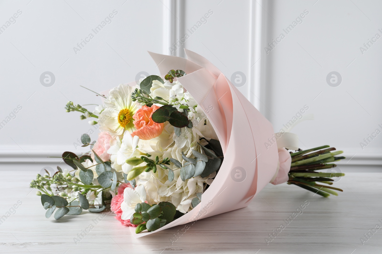 Photo of Bouquet of beautiful flowers on white wooden table