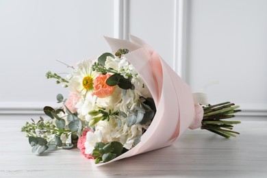 Photo of Bouquet of beautiful flowers on white wooden table