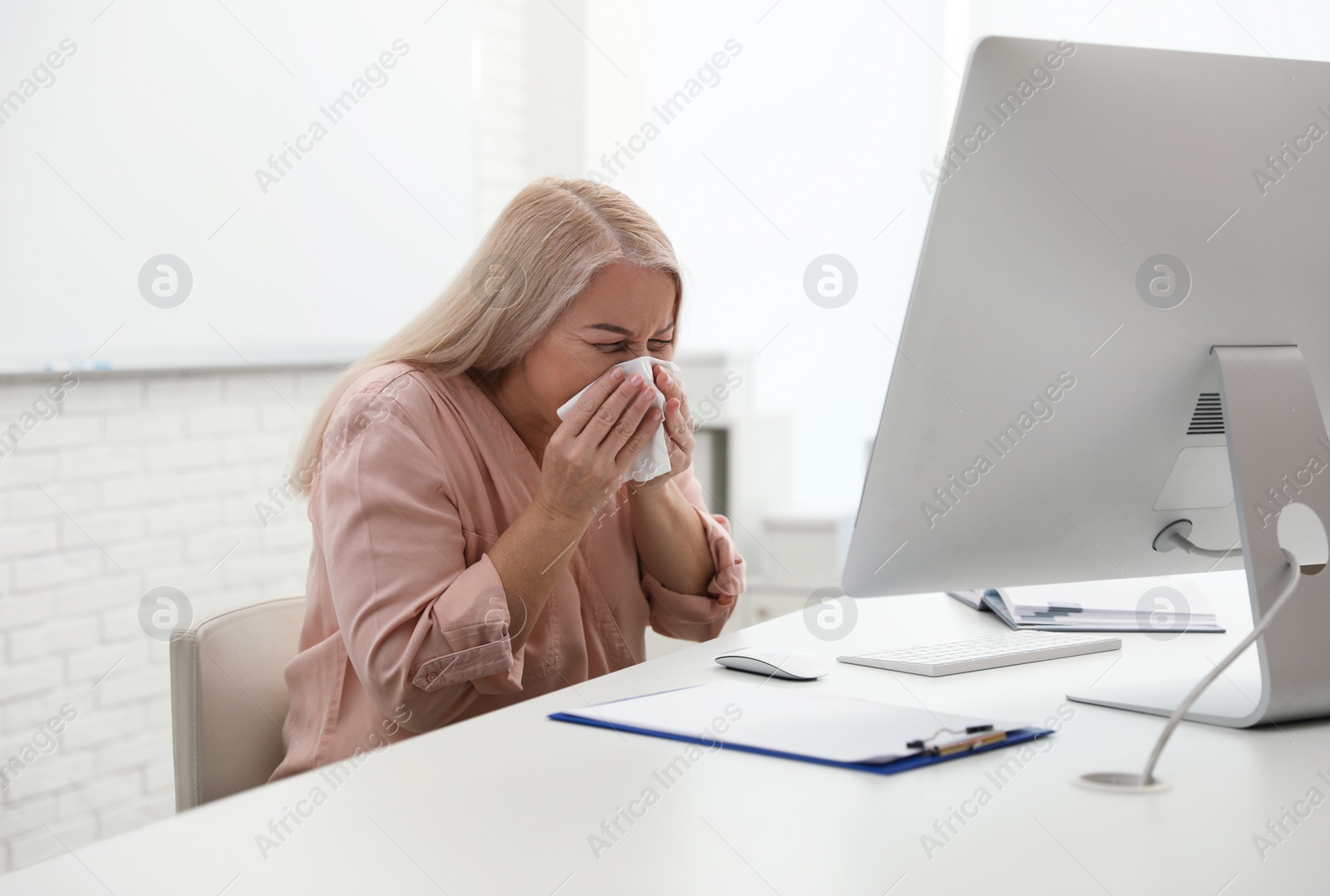 Photo of Sick mature woman at workplace. Dangerous virus