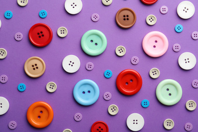 Photo of Different sewing buttons on violet background, flat lay