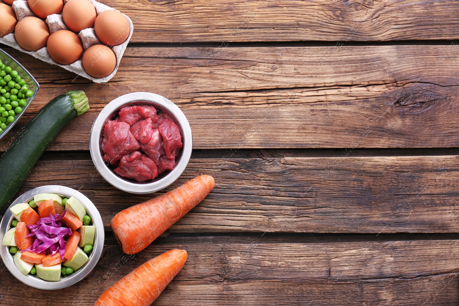 Photo of Flat lay composition with healthy dog food on wooden background. Space for text