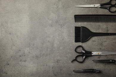 Photo of Professional tools for hair dyeing on grey stone background, flat lay. Space for text