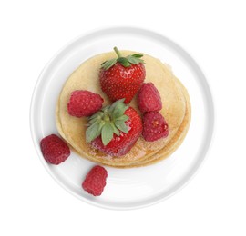 Tasty pancakes with fresh berries and honey on white background, top view