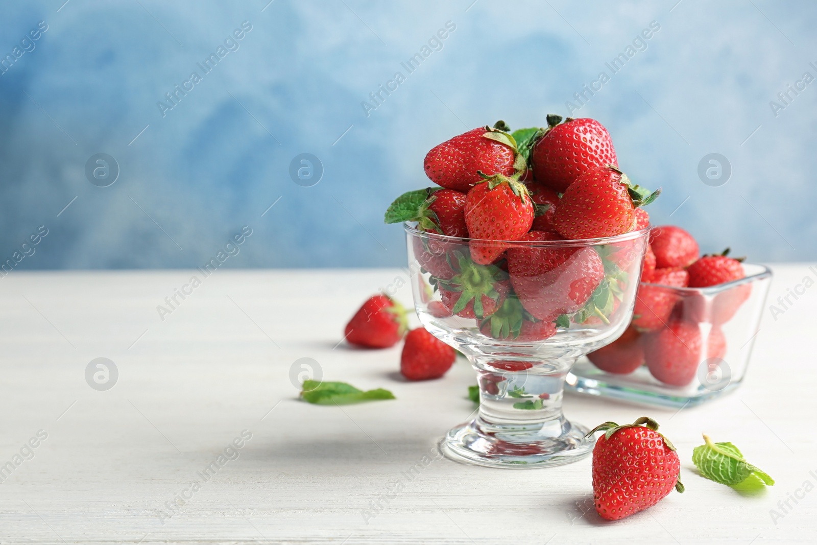 Photo of Dessert bowl with ripe red strawberries on table