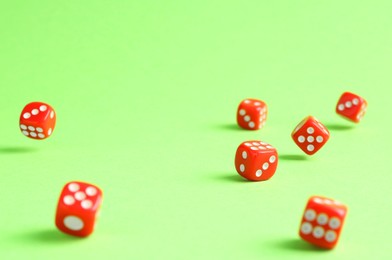 Many red game dices falling on green background