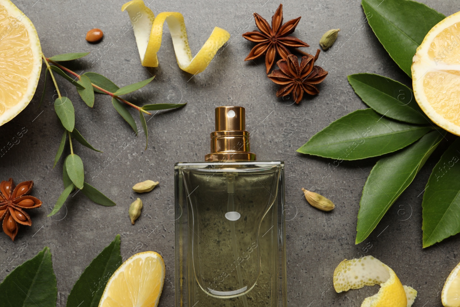 Photo of Flat lay composition with bottle of perfume and fresh citrus fruits on grey table
