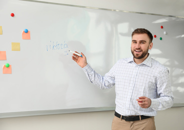 Photo of Portrait of young teacher near whiteboard in classroom