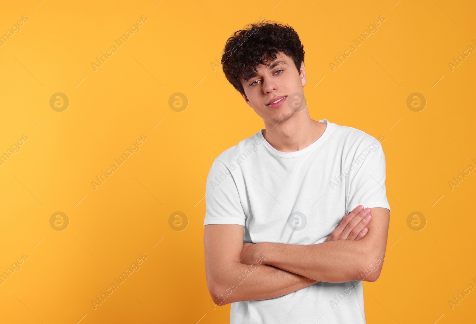 Photo of Portrait of handsome young man on orange background. Space for text