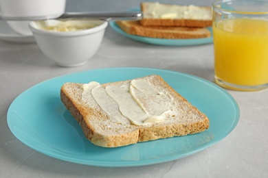 Tasty bread with butter served on grey table