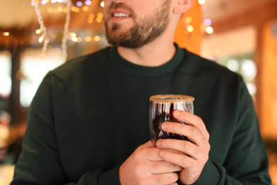 Man with glass cup of tasty mulled wine, closeup