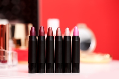 Different lipsticks in row on dressing table