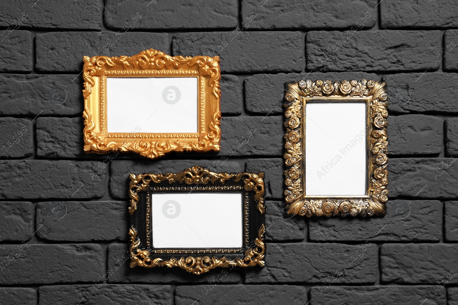 Photo of Empty vintage frames hanging on dark brick wall. Mockup for design