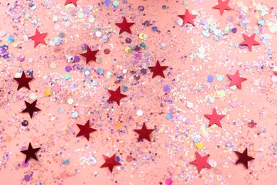 Photo of Shiny glitter on light pink background, above view