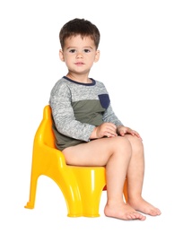 Photo of Portrait of little boy sitting on potty against white background