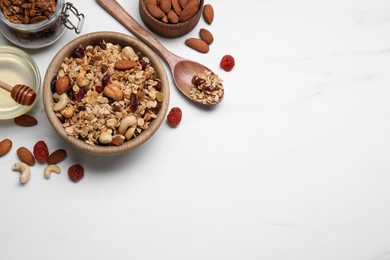 Photo of Tasty granola served with nuts and dry fruits on white marble table, flat lay. Space for text