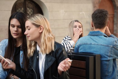 Photo of People smoking cigarettes at public place outdoors