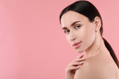 Portrait of beautiful young woman on pink background. Space for text