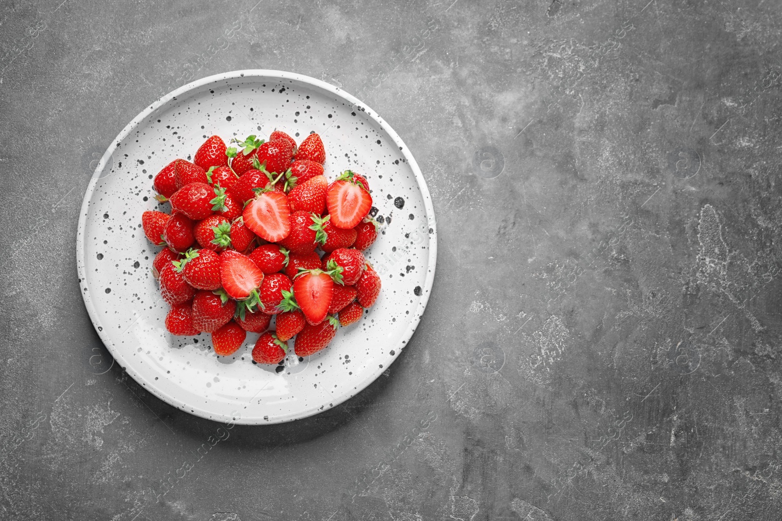 Photo of Plate with ripe strawberries on grey background, top view