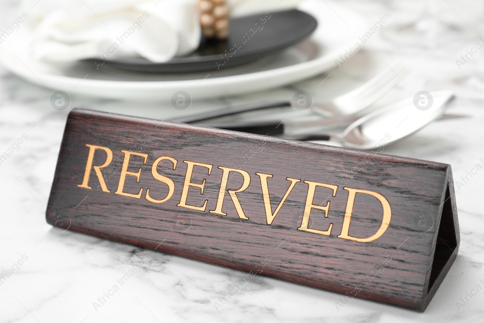 Photo of Table setting with RESERVED sign in restaurant