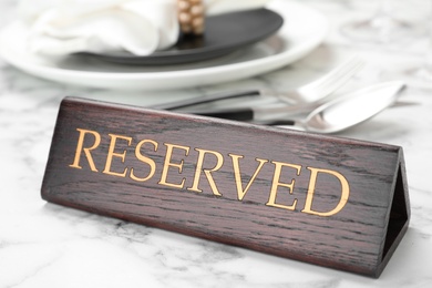 Table setting with RESERVED sign in restaurant