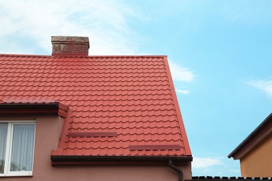 Photo of Beautiful house with red roof against blue sky