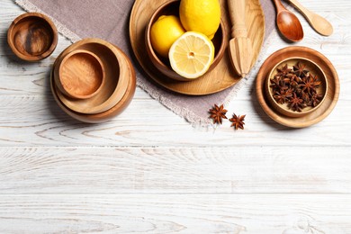 Photo of Beautiful tableware, lemons and anise stars on white wooden table, flat lay. Space for text