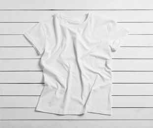 Photo of Stylish t-shirt on white wooden background, top view