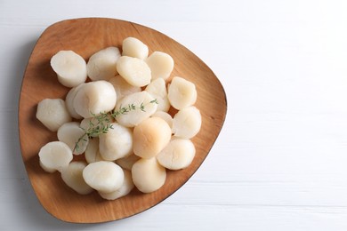 Photo of Fresh raw scallops and thyme on white wooden table, top view. Space for text