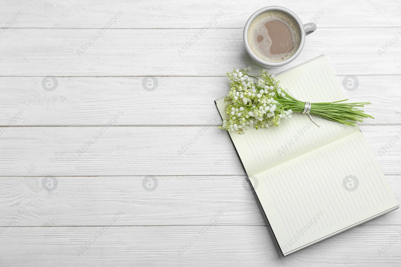 Photo of Flat lay composition with notebook, lily of the valley bouquet and coffee on white wooden background. Space for text