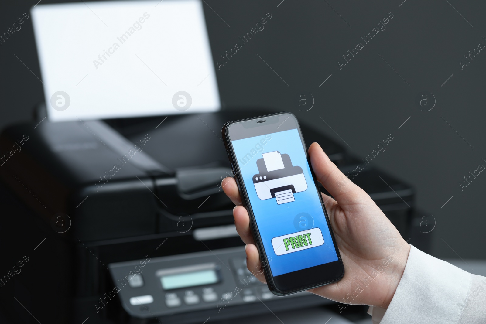 Photo of Man using printer management application on mobile phone indoors, closeup and space for text