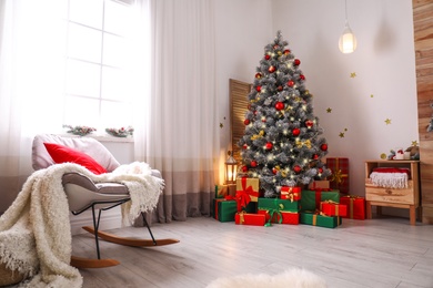 Stylish room interior with beautiful Christmas tree and gift boxes