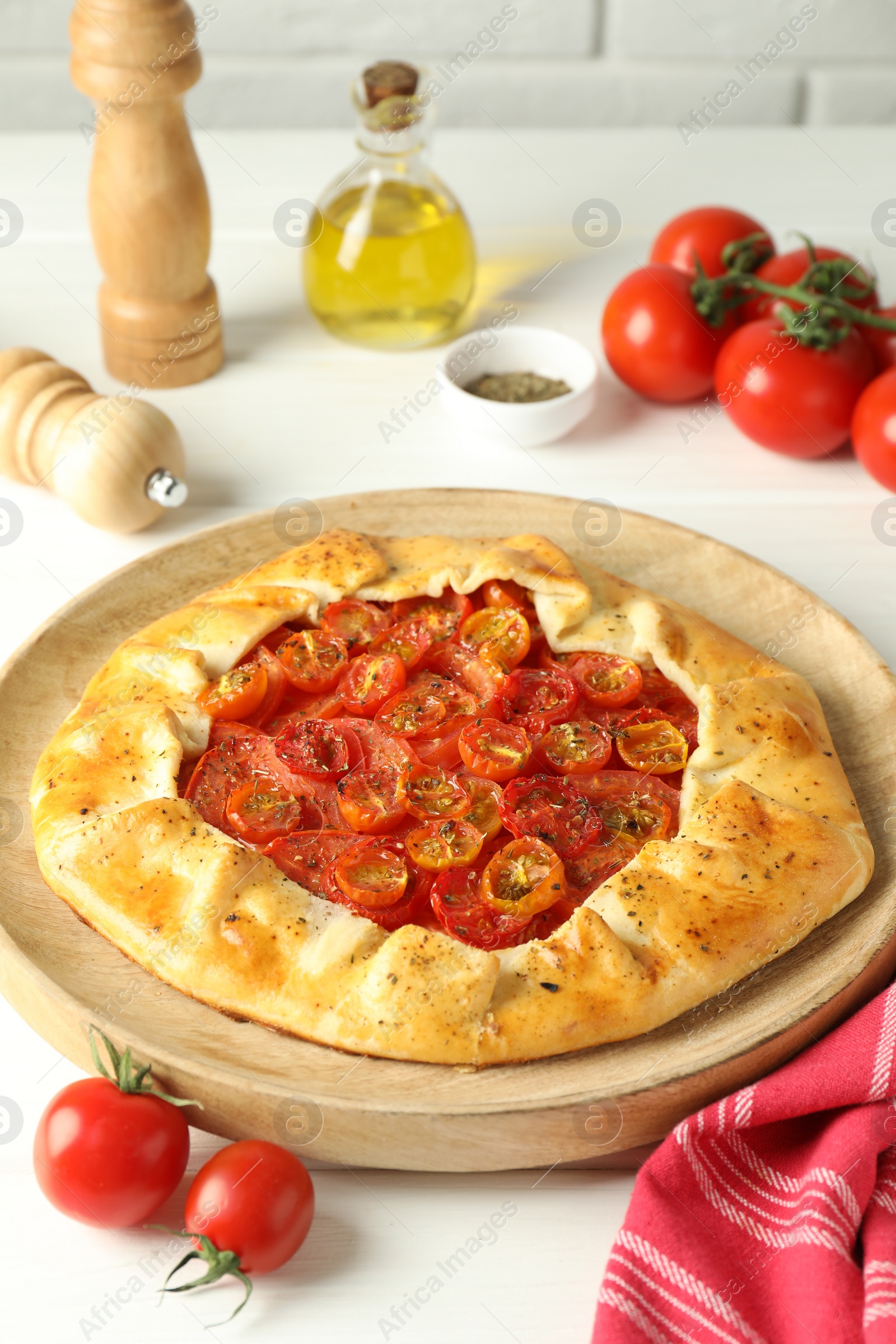 Photo of Tasty tomato galette (Caprese galette) on white wooden table, closeup