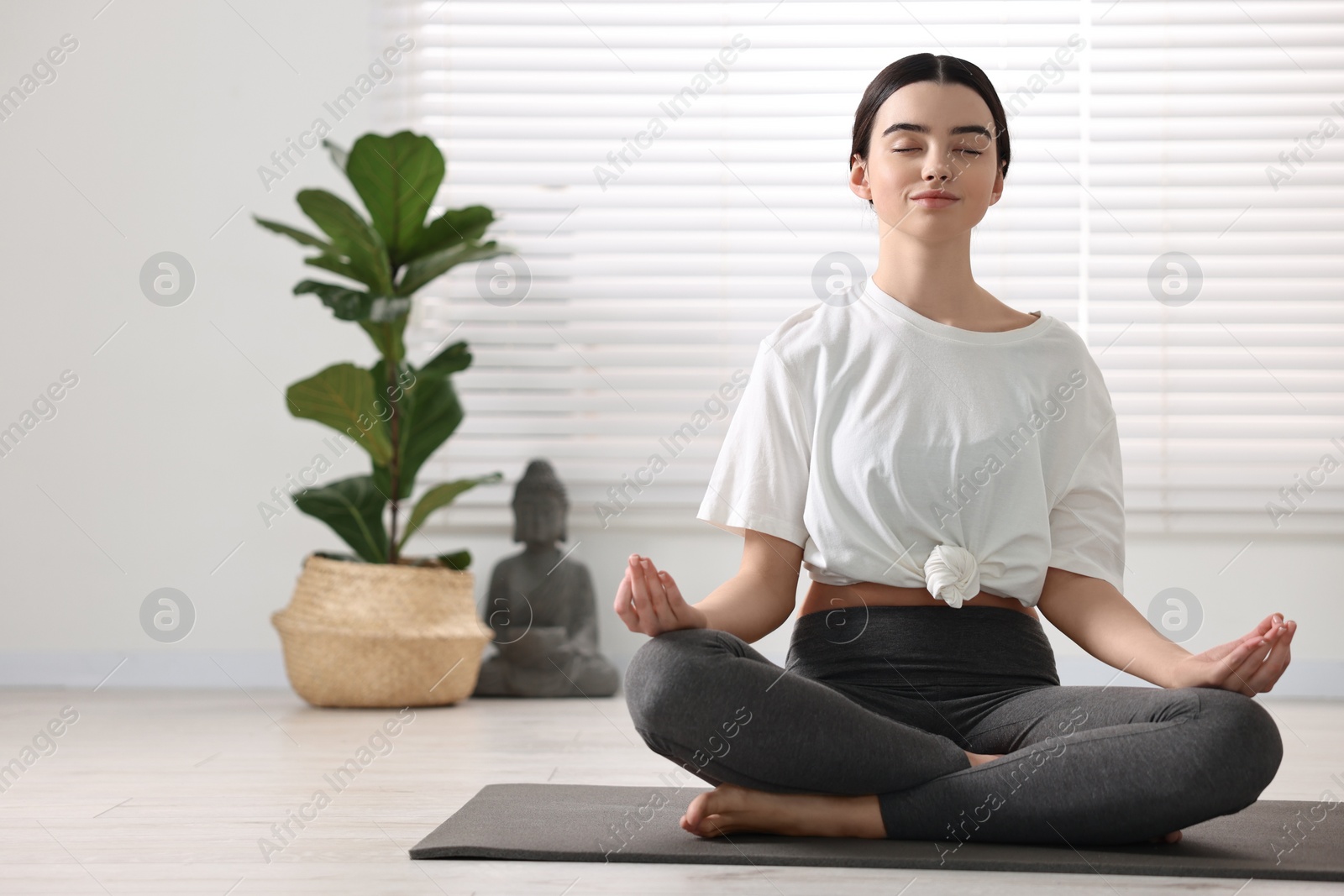 Photo of Beautiful girl meditating on mat in yoga studio