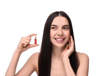 Beautiful young woman holding skincare ampoule on white background