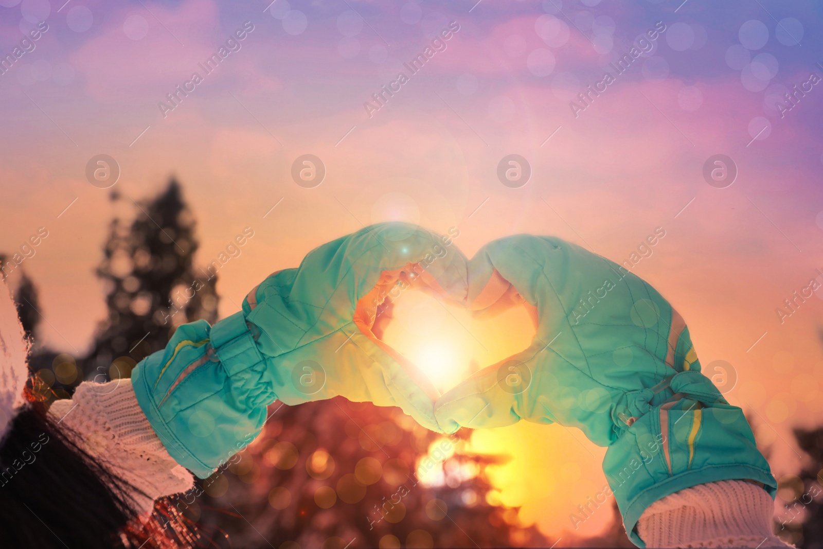Image of Young woman making heart with hands outdoors, closeup. Winter vacation