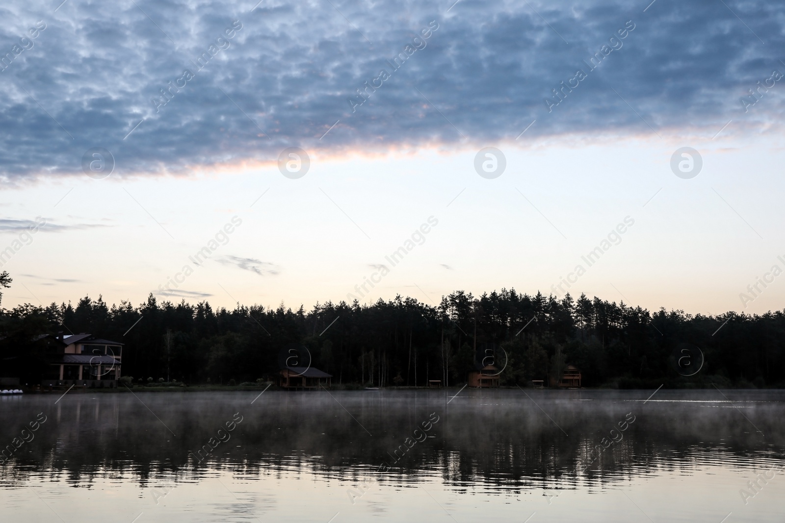 Photo of Beautiful landscape with forest and houses near lake. Camping season